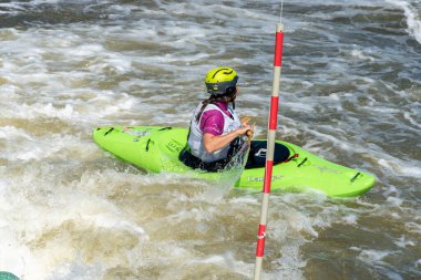 Krakow, Poland - August 27th, 2022: Canoeist struggling with the power of rushing current in whitewater canoening track in Krakow. Extreme sport and adrenaline as great way to spend free time.