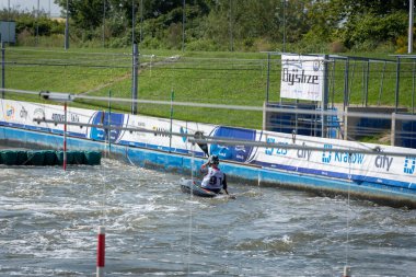 Krakow, Poland - August 27th, 2022: Canoeist struggling with the power of rushing current in whitewater canoening track in Krakow. Extreme sport and adrenaline as great way to spend free time.