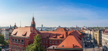 Katowice şehrinin panoraması. Ön planda kırmızı kiremit çatılı neo-gotik tarzda tarihi bir okul binası var. Katowice, Polonya