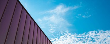 Mavi gökyüzü arka planına karşı bakır levha panelleriyle kaplı bir binanın ayrıntıları