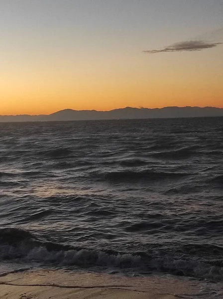 美丽的橙色夕阳笼罩着漆黑的海风 — 图库照片