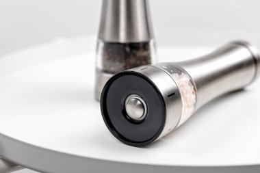 Baharat tuzu ve biber için Mills. Elektrik ve metal. Beyaz bir masada. Kapat.