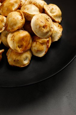 Siyah tabakta kızarmış börek. Rus yemeği. Hamur köftesi. Kapat.