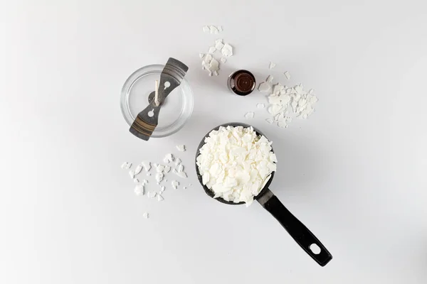 Mum yapımında kullanılan beyaz soya gevreği, parfüm ve fitili olan kavanoz. Flatlay, üst manzara. Beyaz arkaplan