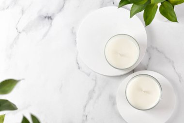 Kokteylli iki kavanoz mum ya da vazo dolusu yeşil yapraklı soya cilası. Beyaz iç potografi