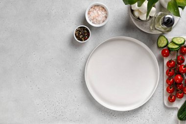 Salata için beyaz boş tabak. Salatalık dilimi, kiraz domatesleri, mozzarella, tuz ve biber için malzemeler. Üst görünüm.