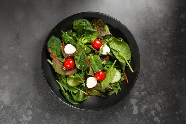 深色的新鲜绿叶沙拉盘 配上牛油果 樱桃西红柿 灰背景的莫扎拉 顶部视图 — 图库照片