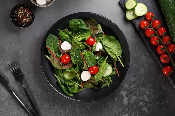 新鲜的绿色色拉叶 配以杜鹃 樱桃西红柿 深色底盘上的莫扎瑞拉 叉子和刀 绿色饮食 — 图库照片