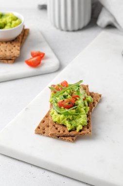 Ekmeğe avokado ezmeli sandviç, kirazlı domates ve ar.