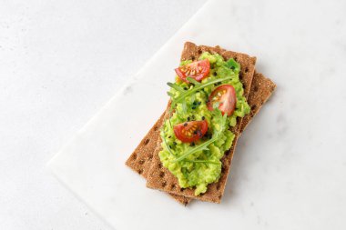 Lezzetli avokado tostları, kiraz ve siyah susam tohumları. Üst Manzara. Minimalizm