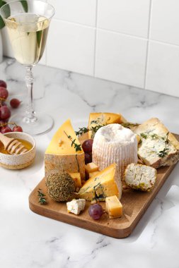 Tahtadaki farklı çeşit lezzetli peynir ve şarap. Shropshire, langre, asiago, gorgonzola, shankish peyniri.