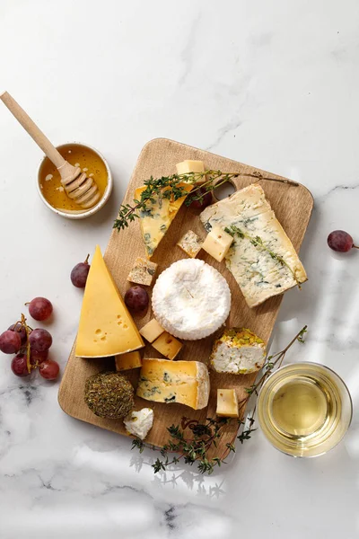 Peynir tabağı, shropshire, langre, asiago, gorgonzola, ahşap tahtada shankish peyniri. Üst Manzara. Bal ve şarap.
