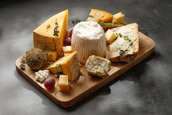 Koyu masada peynir tabağı. Gorgonzola, shanklish peyniri, Shropshire, langre, asiago peyniri tahtada.
