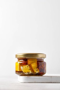 Kavanozda doğal Yunan peyniri, zeytinyağı ve bitkilerle dolu cam kavanoz. Asgari