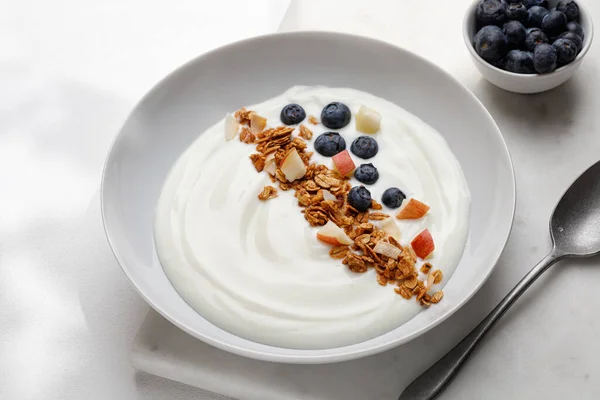Fındıklı granola, yoğurt ve kasede böğürtlen. Müsli, yoğurt ve yabanmersinli doğa kahvaltısı, beyaz arka plan..