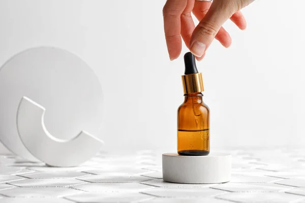 Kadın aromatik losyon, yağ, Hyaluronic asit ya da kahverengi şişede pipetle kolajen kullanıyor. Model
