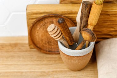 Mutfak eşyaları seramik bardakta, tahta kaşıklar, bıçaklar, bal kaşığı. Döşeme arkaplanı