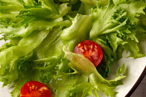 Tabakta domatesli Frillis salatası. Yeşil salata yapraklarıyla