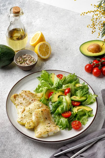Sebze üzerine kızarmış halibut balığı ve taze yeşil salata. Üst Manzara. Siyah tabak. Oli ve limon