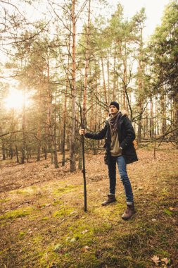 Çam ormanındaki yeşil yosunların üzerinde sihirli değnekle duran mistik av bekçisi..
