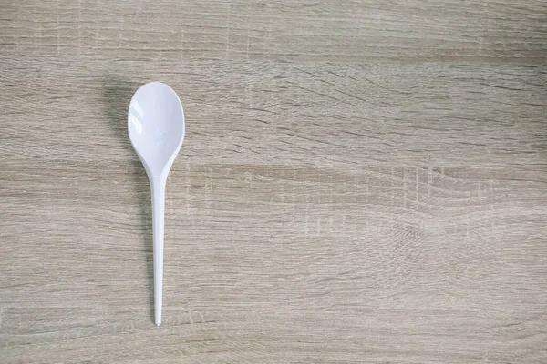 White Plastic Spoon Wooden Table — Stock Photo, Image