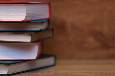 stack of colorful books on wooden table, closeup