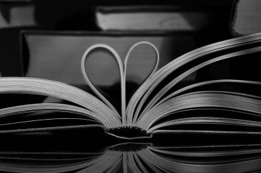 Ahşap arka planda kalp şeklinde bir kitap aç