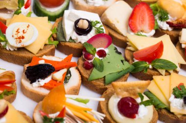 Füme somon, salatalık, vişneli domates ve mozarella ile servis edilen farklı kanepeler.