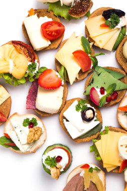 Füme somon, salatalık, vişneli domates ve mozarella ile servis edilen farklı kanepeler.