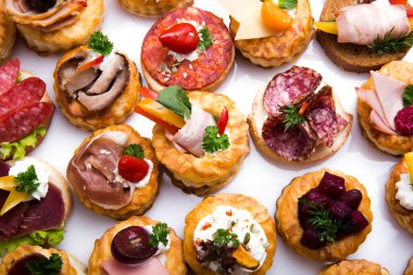 Füme somon, salatalık, vişneli domates ve mozarella ile servis edilen farklı kanepeler.