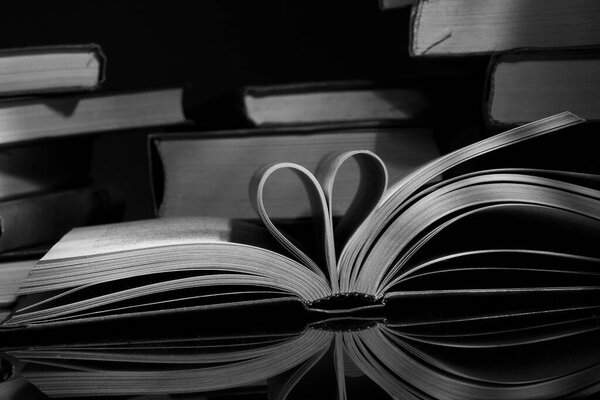 Open book with a heart on a black background