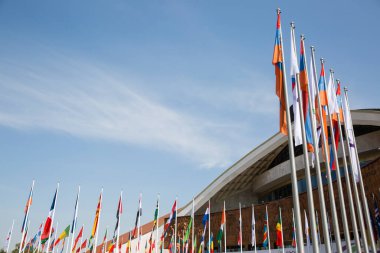 mavi gökyüzüne karşı farklı ülkelerin bayrakları