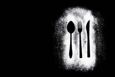 Siyah beyaz bir çatalın siyah arka planda kaşıkla çekilmiş fotoğrafı.