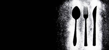 Siyah beyaz bir çatalın siyah arka planda kaşıkla çekilmiş fotoğrafı.