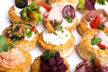 Füme somon, salatalık, vişneli domates ve mozarella ile servis edilen farklı kanepeler.