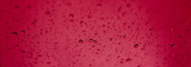 Su damlaları siyah arka planda bardağa düşer.