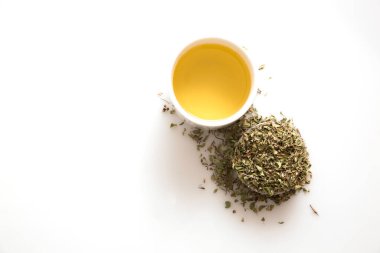 Beyaz arka planda izole edilmiş yeşil çay ve otların üst görüntüsü