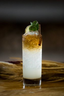 Tahta bir fıçının üzerinde alkollü bir kokteylin yakın çekimi.