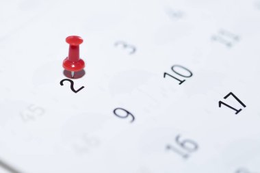 Beyaz arkaplanda iğne olan bir tarihin yakın plan çekimi