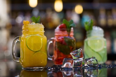 Pürüzsüz bir masada, mason kavanozlarında soğuk meyve çayı.