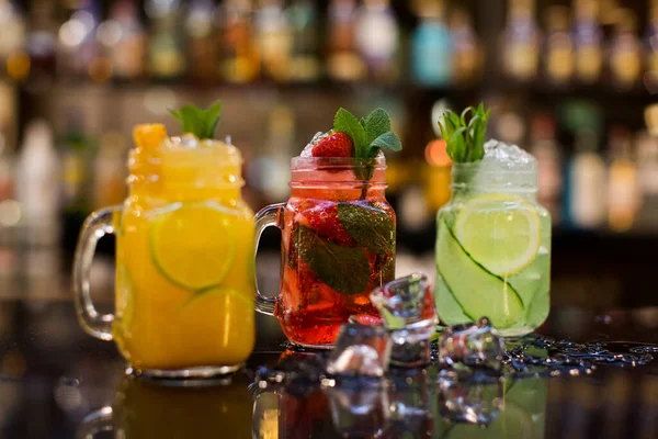 Pürüzsüz bir masada, mason kavanozlarında soğuk meyve çayı.