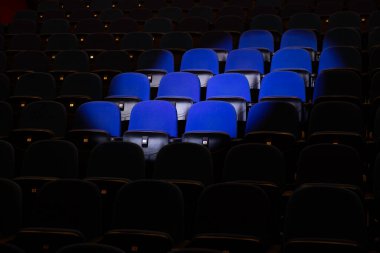Close up shot of interior of cinema auditorium with lines of blue chairs. Horizontal shot
