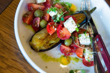 salad with cheese and fresh vegetables on a white plate