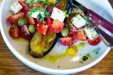 salad with cheese and fresh vegetables on a white plate