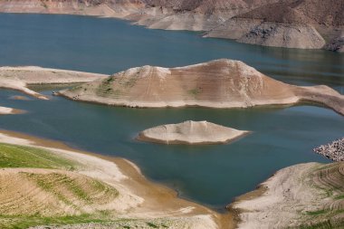 Ermenistan 'da parlak turkuaz rengi ve arka planda kurak arazisi olan Azat Nehri rezervuarı olan bir dağ vadisi manzarası.