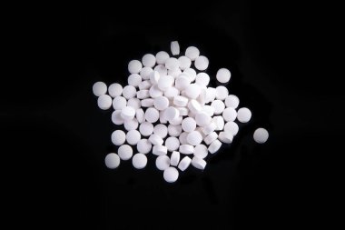 Bir yığın beyaz ve siyah arka planda bir yığın ilaç var.