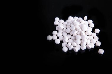 Bir yığın beyaz ve siyah arka planda bir yığın ilaç var.