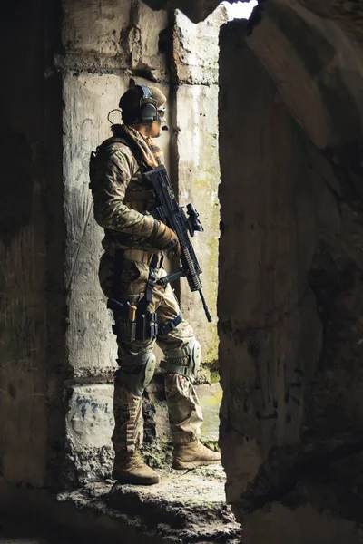 Guarding pose with heavily armed suit at border building — Stock Photo, Image