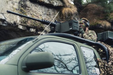 Kamyonda makineli tüfekle öfkelenen hırpalanmış çaylak asker. 