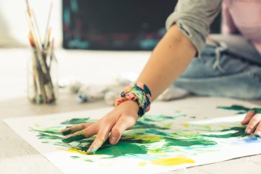 Soyut sanat. Çağdaş ressam elleriyle tuvale resim çiziyor. Yakın çekim.
